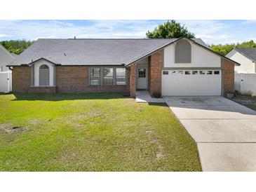 Charming single-story brick home with a well-manicured lawn, attached garage, and welcoming front entrance at 118 White Birch Dr, Kissimmee, FL 34743