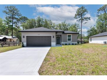 Charming single-story home featuring a gray exterior, two-car garage, and a well-manicured lawn at 1686 17Th St, Orange City, FL 32763