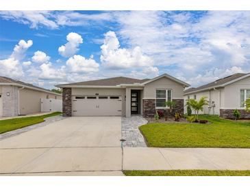 Charming single-story home with a two-car garage, stone accents, and a well-manicured lawn at 236 Pink Ibis Bnd, St Cloud, FL 34772
