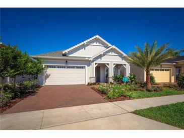 Charming single-story home featuring a brick driveway, lush landscaping, and a welcoming covered entryway at 2454 Dream Home Ct, St Cloud, FL 34772