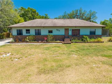 Charming single-story home featuring a well-maintained lawn and brick-accented garden beds under a clear blue sky at 3975 Rambler Ave, St Cloud, FL 34772