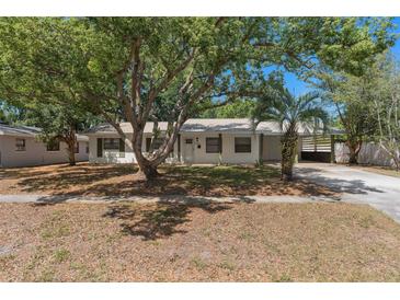 Charming single-story home featuring lush mature trees and a metal roof at 5326 Weirwood Ave, Orlando, FL 32810