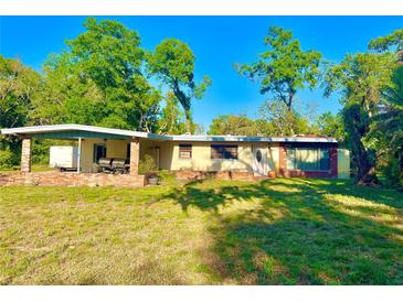 Single story home featuring a porch and yard surrounded by mature trees under a sunny blue sky at 1221 Oak Haven Dr, Altamonte Springs, FL 32714