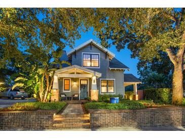 Charming two-story home featuring a brick walkway, front porch, and mature trees at 13 Hill Ave, Orlando, FL 32801