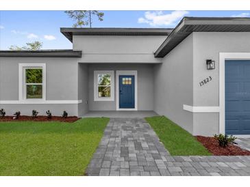 Charming home featuring a blue front door and a well-maintained brick walkway at 15823 Sw 27Th Avenue Rd, Ocala, FL 34473