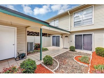 Charming patio area with decorative rock and mulch, covered area and exterior door at 1728 Townhall Ln # 1728, Orlando, FL 32807