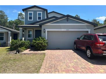 Charming two-story home with a brick driveway and well-maintained landscaping at 17333 Cagan Crossings Blvd, Clermont, FL 34714