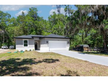 Charming single-story home featuring a two-car garage, fresh landscaping, and a well-manicured lawn at 1819 Carr St, Deland, FL 32720