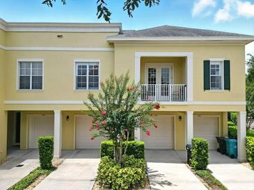 Townhouse exterior with charming balcony and manicured landscaping at 1845 Common Way Rd # 28-206, Orlando, FL 32814