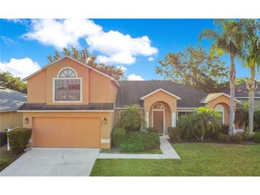 Inviting two-story home with well-maintained landscaping, mature palms, and attached two-car garage at 847 Coventry Rd, Davenport, FL 33897