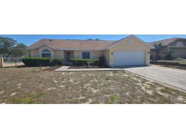 Charming one-story home featuring a well-manicured front yard and an attached two-car garage at 129 Valentino Ct, Davenport, FL 33837