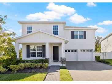 Charming two-story home boasting a well-manicured lawn, covered porch and two-car garage at 13242 Orange Isle Dr, Windermere, FL 34786