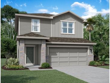 Charming two-story home featuring neutral siding, brick accents, a two-car garage, and a well-manicured lawn at 1451 Dalkeith Cv, Sanford, FL 32771