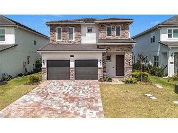 Beautiful two-story home featuring stone accents, a two-car garage, and a meticulously maintained front lawn at 15727 Vetta Dr, Montverde, FL 34756