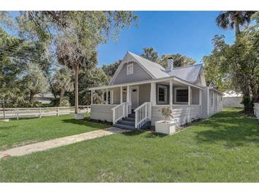 Charming home featuring a quaint porch, well-maintained lawn, and a classic gray exterior finish at 246 N Oak Ave, Orange City, FL 32763