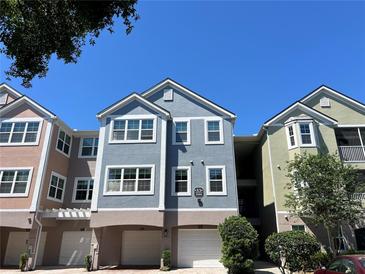 Three-story condo building with attached garages and colorful exterior paint at 3344 Corona Village Way # 205, Orlando, FL 32835