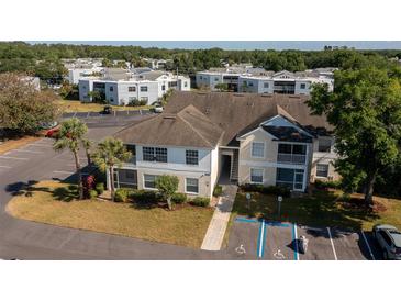 Exterior view of a two-story condo building with reserved parking and tropical landscaping at 3960 Southpointe Dr # 501, Orlando, FL 32822