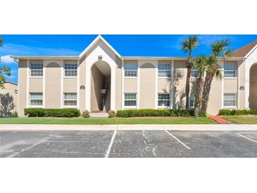 Inviting condo building with lush landscaping, clear blue skies, and well-maintained parking area at 4403 Hector Ct # 3, Orlando, FL 32822