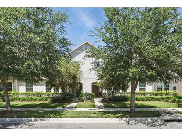 Charming two-story townhouse with meticulously landscaped front yard and mature trees at 5838 Cypress Hill Rd, Winter Garden, FL 34787