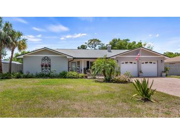 Charming single-story home with a manicured front lawn and a two-car garage in a residential neighborhood at 8444 Sandberry Blvd, Orlando, FL 32819
