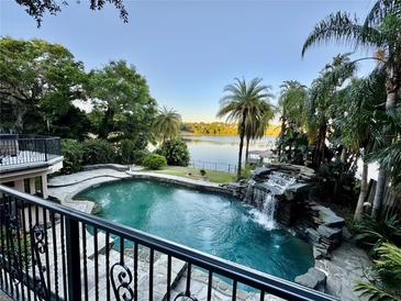 Beautiful pool and spa with waterfall feature overlooks lake at 1105 Lake Nettie Dr, Eustis, FL 32726