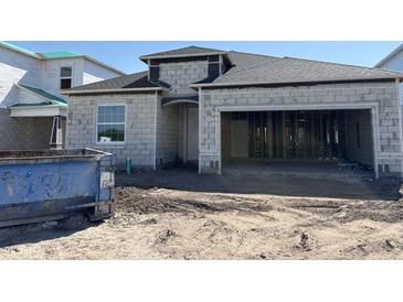 Under construction exterior with gray concrete walls, a garage door opening, and window on a sunny day at 1161 Basalt Ln, Sanford, FL 32771