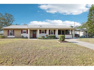 Charming single-story home with a well-maintained lawn, metal roof, and colorful accents at 2314 Falkner Rd, Orlando, FL 32810