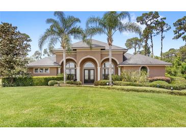 Charming home featuring mature landscaping, well manicured lawn and striking entryway at 2825 Lakeshore Dr, Mount Dora, FL 32757