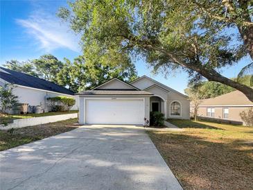 Charming single-story home with a two-car garage, mature tree, and well-maintained lawn at 30442 Pga Dr, Sorrento, FL 32776