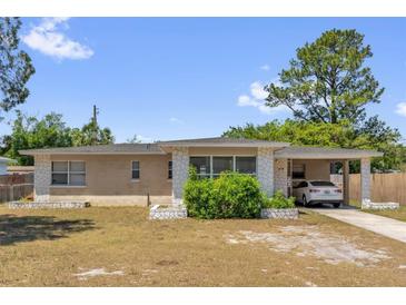 Charming single-story home featuring stone accents, a covered carport, and a well-maintained front yard at 4108 Drexel Ave, Orlando, FL 32808