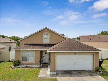 Charming home featuring a two-car garage, neutral paint, and manicured lawn at 5118 Luna Negra Dr, Orlando, FL 32811
