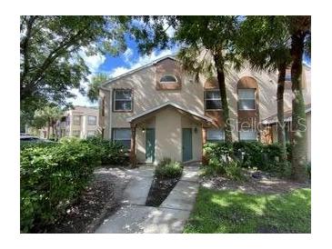 Inviting townhome featuring neutral tones and well-manicured landscaping and mature trees at 5468 E Michigan E St # 4, Orlando, FL 32812