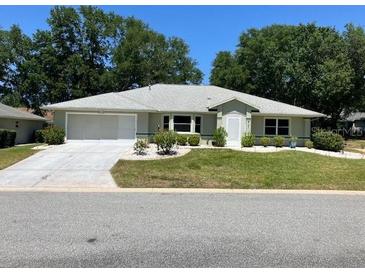 Charming single-story home featuring a well-maintained lawn, mature trees, and a two-car garage at 6419 Borg St, Leesburg, FL 34748