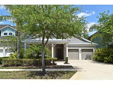 Charming home features lush landscaping, a two-car garage, and a welcoming front porch for relaxing at 8742 Peachtree Park Ct, Windermere, FL 34786