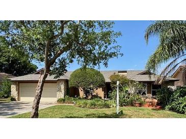 Charming single-story home featuring a two-car garage and well-manicured lawn with beautiful trees and shrubs at 1139 Fairway Dr, Winter Park, FL 32792