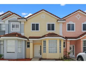 Charming townhomes with colorful facades, brown tile roofs, and well-maintained landscaping at 1236 S Beach Cir, Kissimmee, FL 34746