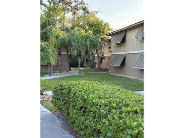 Exterior view showcasing the lawn, landscaping, and architectural details of the building at 130 Jasmine Woods Ct # 6D, Deltona, FL 32725