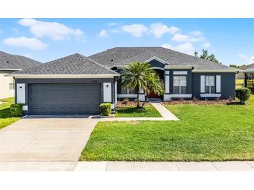 Charming single-story home boasts a well-manicured lawn and attached two-car garage at 13606 Summer Rain Dr, Orlando, FL 32828