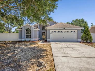 Charming single-Gathering home featuring a two-car garage, well-maintained lawn, and mature trees at 150 Bentley Oaks Blvd, Davenport, FL 33896