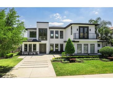 Contemporary two-story home featuring a modern design, manicured landscaping, and a spacious driveway at 1700 Palm Ave, Winter Park, FL 32789