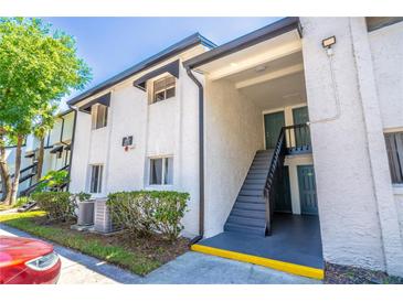 Two-story exterior view of condo building with stairs leading to upper units at 4117 S Semoran Blvd # 17, Orlando, FL 32822
