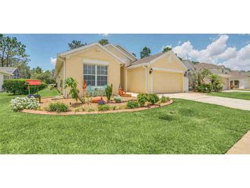 Charming single-story home with a well-manicured lawn and colorful landscaping along the front at 715 Troon Cir, Davenport, FL 33897