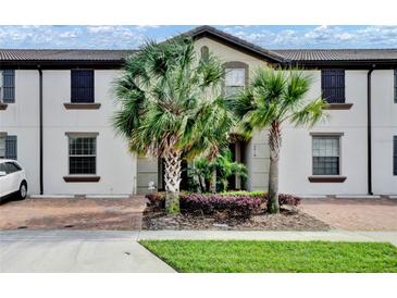 Inviting townhouse featuring meticulously landscaped frontage and private brick paved driveway at 8814 Geneve Ct, Kissimmee, FL 34747