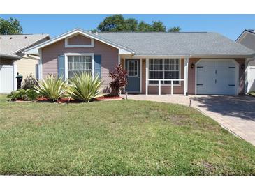Charming single-story home with a well-manicured lawn, tiled walkway and attached one car garage at 9313 Pavillion Dr, Orlando, FL 32825