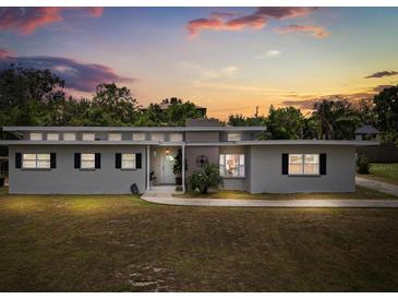 Charming single-story home with a well-manicured lawn at sunset at 932 Campbell Ave, Lake Wales, FL 33853