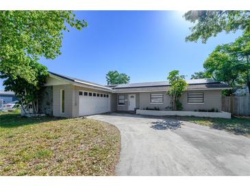 Charming single-story home featuring a two-car garage, a welcoming front yard, and solar panels on the roof at 941 Barbados Ave, Orlando, FL 32825