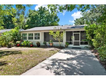 Charming single-story home featuring a screened-in porch and a well-maintained front yard with mature trees at 108 S Glenwood Ave, Orlando, FL 32803