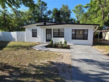 Charming white home featuring a well manicured lawn and a concrete driveway at 1125 W 8Th St, Lakeland, FL 33805