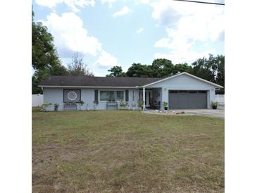 Charming one-story home featuring a well-manicured lawn, tidy landscaping, and a two-car garage at 1160 Rolling Acres Dr, Deland, FL 32720