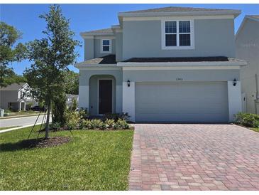 Charming two-story home with a well-manicured lawn and brick driveway at 1243 Bear Oak Ln, Deland, FL 32720